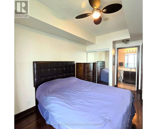 A bedroom with a bed and a ceiling fan.