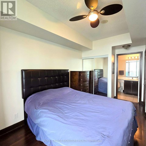 A bedroom with a bed and a ceiling fan.