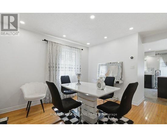 A dining room with a white table and black chairs.