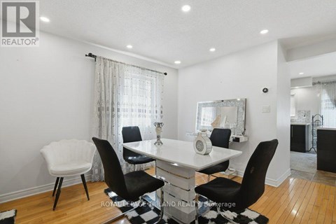 A dining room with a white table and black chairs.
