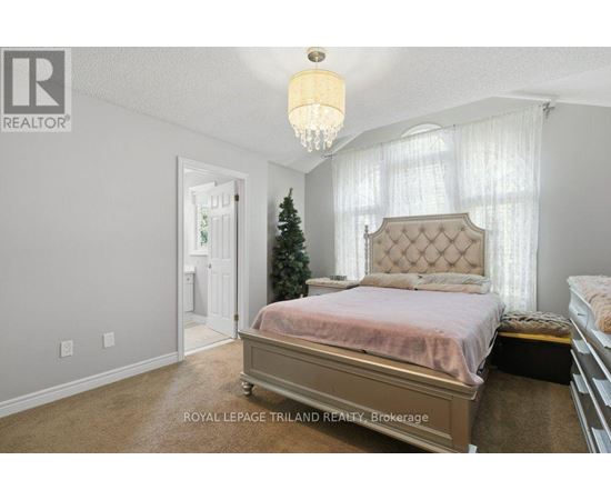 A bedroom with a large bed and a Christmas tree in the corner.