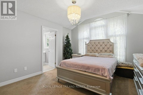 A bedroom with a large bed and a Christmas tree in the corner.