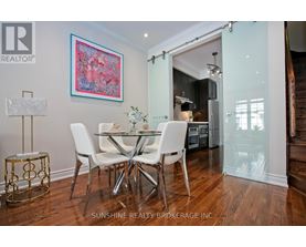 A dining room with a table set for two and a painting on the wall.