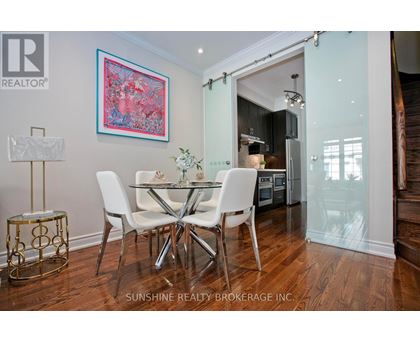 A dining room with a table set for two and a painting on the wall.
