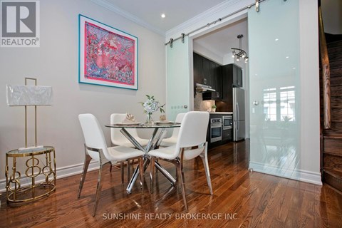 A dining room with a table set for two and a painting on the wall.