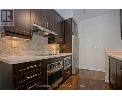 A kitchen with dark wood cabinets and a white countertop.