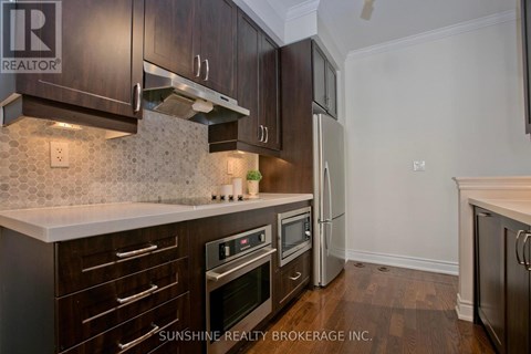 A kitchen with dark wood cabinets and a white countertop.