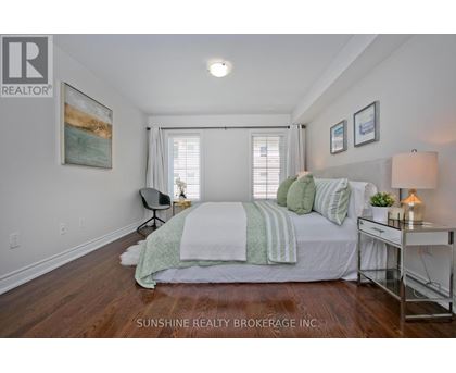 A bedroom with a bed, chair, and a painting on the wall.
