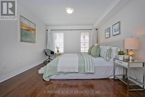 A bedroom with a bed, chair, and a painting on the wall.