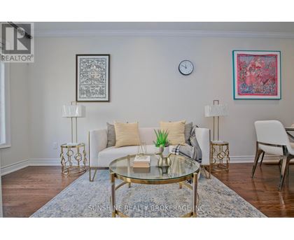 A living room with a glass table and a white couch.