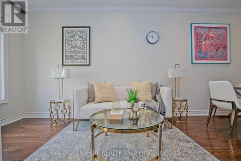 A living room with a glass table and a white couch.
