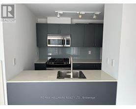 A kitchen with a sink and a stove top oven.