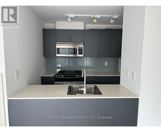 A kitchen with a sink and a stove top oven.