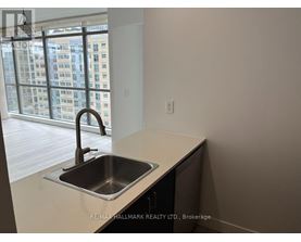 A kitchen with a sink and a window overlooking a city.