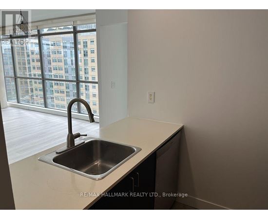 A kitchen with a sink and a window overlooking a city.