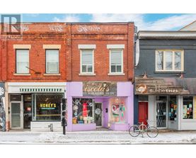 A street view of a row of shops with a bicycle parked in front of them.