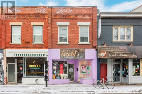 A street view of a row of shops with a bicycle parked in front of them.