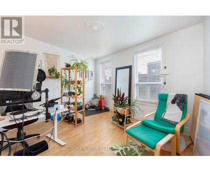 A living room with a green chair and a wooden shelf.