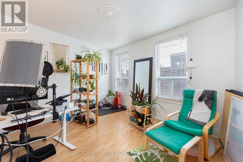 A living room with a green chair and a wooden shelf.