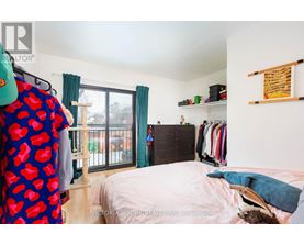 A bedroom with a bed, a wardrobe, and a window with curtains.