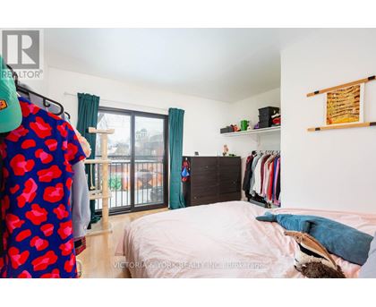 A bedroom with a bed, a wardrobe, and a window with curtains.
