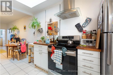 A kitchen with a stove top oven and a refrigerator.