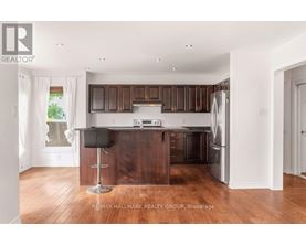 A kitchen with brown cabinets and a black bar stool.
