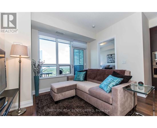 A living room with a couch, a lamp, and a glass table.