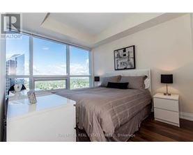 A bedroom with a large bed and a view of the city.