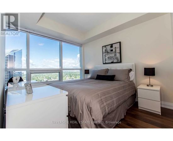 A bedroom with a large bed and a view of the city.