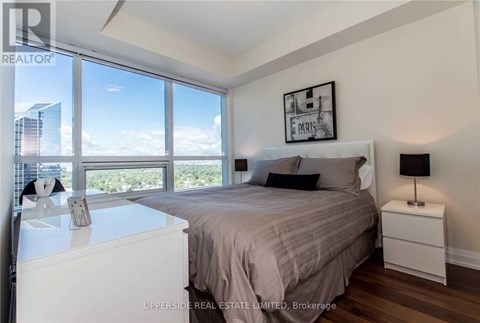 A bedroom with a large bed and a view of the city.