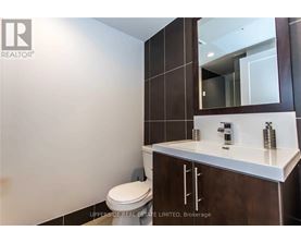 A bathroom with a toilet, sink and mirror.