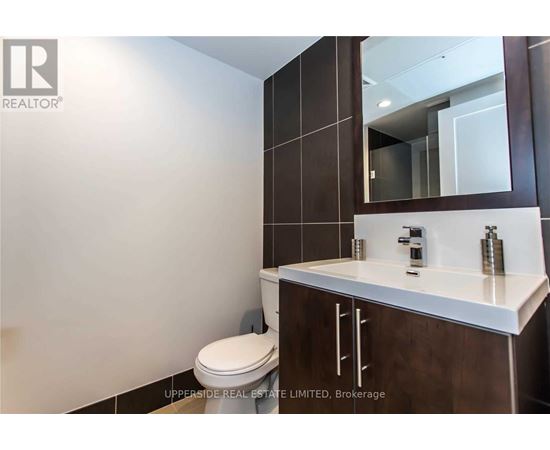 A bathroom with a toilet, sink and mirror.