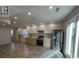 A spacious kitchen with wooden cabinets and stainless steel appliances.