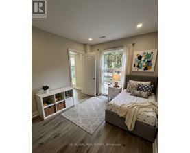 A bedroom with a large bed and a window with curtains.