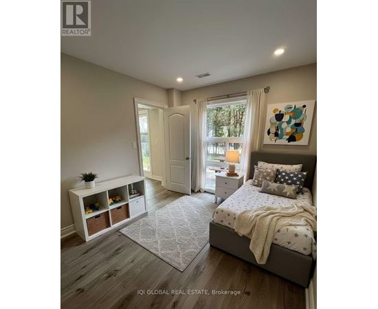 A bedroom with a large bed and a window with curtains.