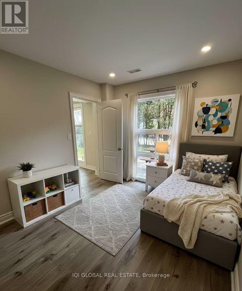 A bedroom with a large bed and a window with curtains.