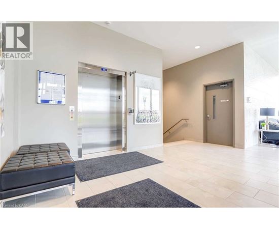 A modern office lobby with a bench, two doors, and a staircase.