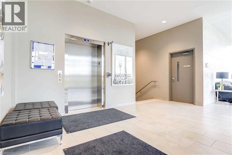 A modern office lobby with a bench, two doors, and a staircase.