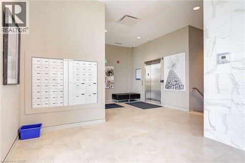 A hallway with a white wall and a calendar on the wall.