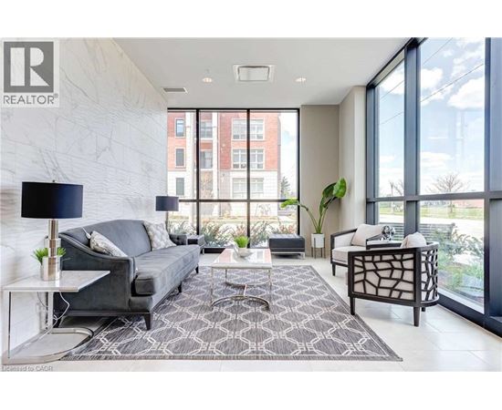 A living room with a grey couch and a black floor lamp.