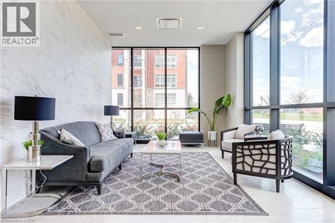 A living room with a grey couch and a black floor lamp.