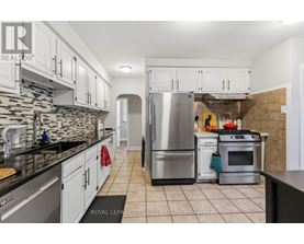 A kitchen with white cabinets and a stone backsplash.