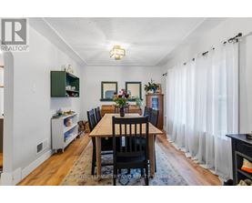 A dining room with a wooden table and chairs.