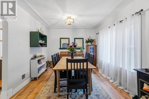 A dining room with a wooden table and chairs.