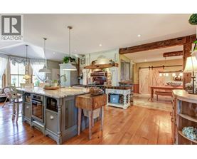 A large, open-plan kitchen and living room with wooden floors and a mix of modern and rustic furniture.