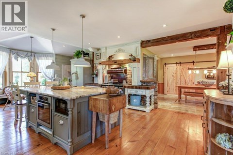 A large, open-plan kitchen and living room with wooden floors and a mix of modern and rustic furniture.