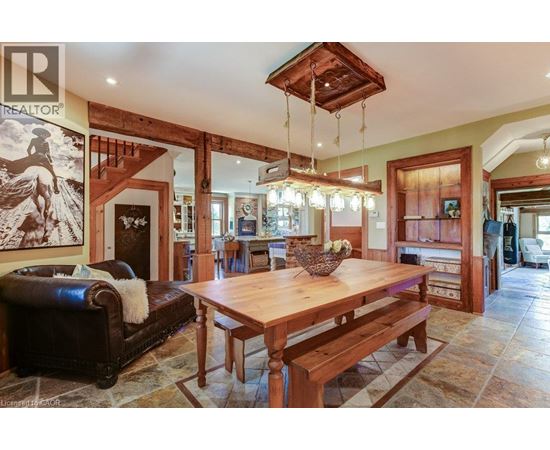 A living room with a wooden table and bench, a couch, and a painting of a horse on the wall.