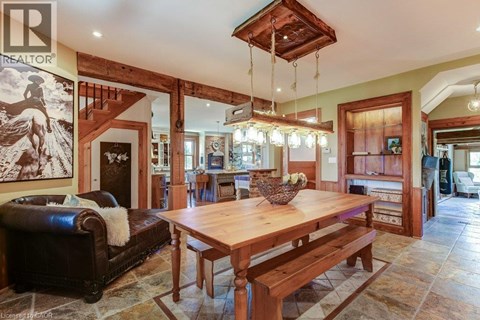 A living room with a wooden table and bench, a couch, and a painting of a horse on the wall.