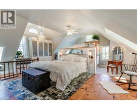 A bedroom with a large bed and a ceiling fan.